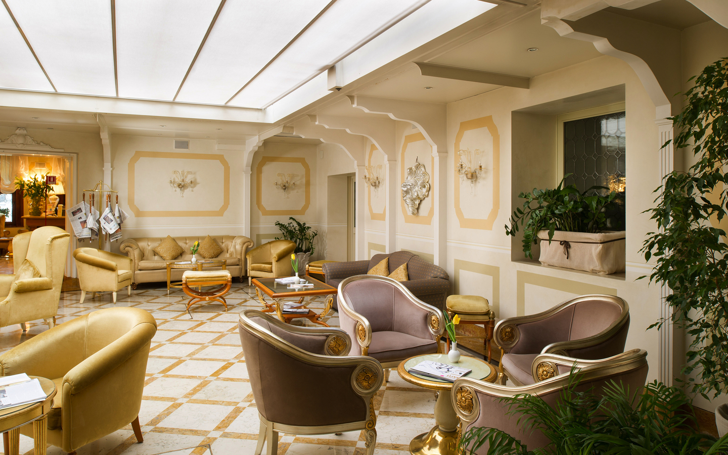Elegante Hotel-Lounge mit stilvollen Sesseln und Tischen, helle Wandverzierungen.