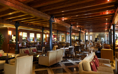 Geräumige Lobby-Bar mit Holzbalkendecke, gemütlichen Sitzbereichen und stilvoller Einrichtung.
