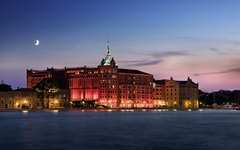 Hilton Molino Stucky bei Dämmerung mit beleuchteter Fassade in Venedig