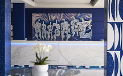 Moderne Hotel-Lobby mit Kunstwerk an der Wand und Orchidee im Vordergrund.