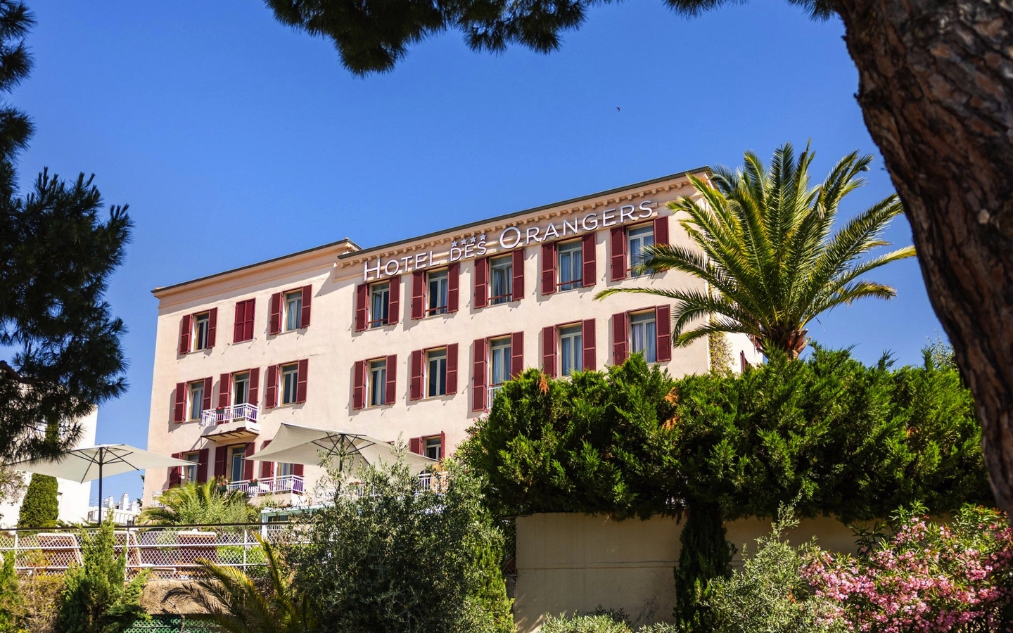 Hotelgebäude mit Palmen und blauen Himmel, Best Western des Orangers, Côte d'Azur.