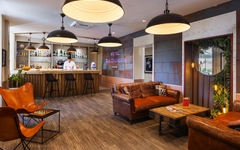 Hotelbar mit Lederstühlen und Bartresen, moderne Dekoration, warmes Ambiente.