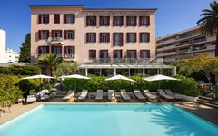 Außenansicht des Hotels mit Pool und Liegestühlen auf der Côte d’Azur.