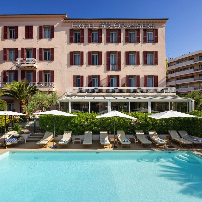 Außenansicht des Hotels mit Pool und Liegestühlen auf der Côte d’Azur.