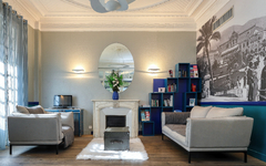 Lobby des Hôtel Excelsior mit Sofas, Kamin und dekorativem Spiegel.
