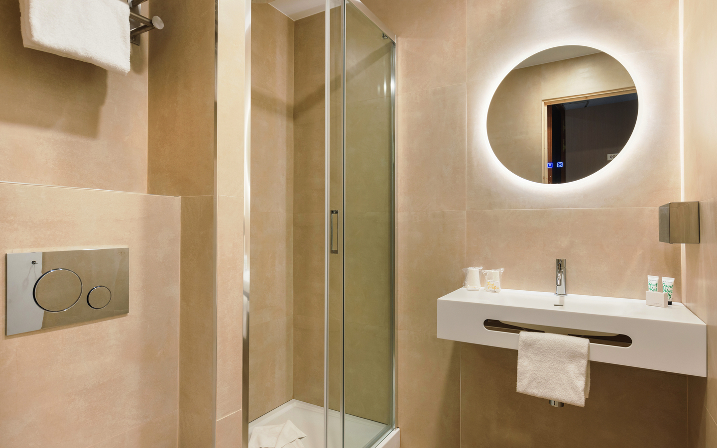 Modernes Badezimmer mit Dusche, rundem Spiegel und Waschbecken in neutralen Tönen.