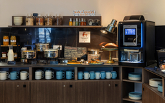 Frühstücksraum mit Buffet, Kaffeeautomat, Geschirr und Lebensmitteln im Hotel KHLA Cote d'Azur.