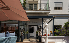 Eingang des Hotels Le Canberra mit Terrasse und Dekor.