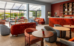Moderner Hotel-Lounge-Bereich mit Sitzgruppen und Bar.