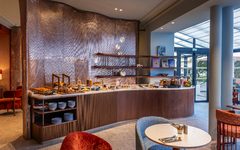 Buffetbereich in modernem Hotel mit Tischen und Stühlen.