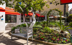 Gartenbereich mit Bank und blühenden Pflanzen im Hotel Brice Garden, Côte d'Azur.