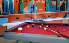 Billardtisch mit roten Tuch und einem Glas Bier in moderner Lounge.
