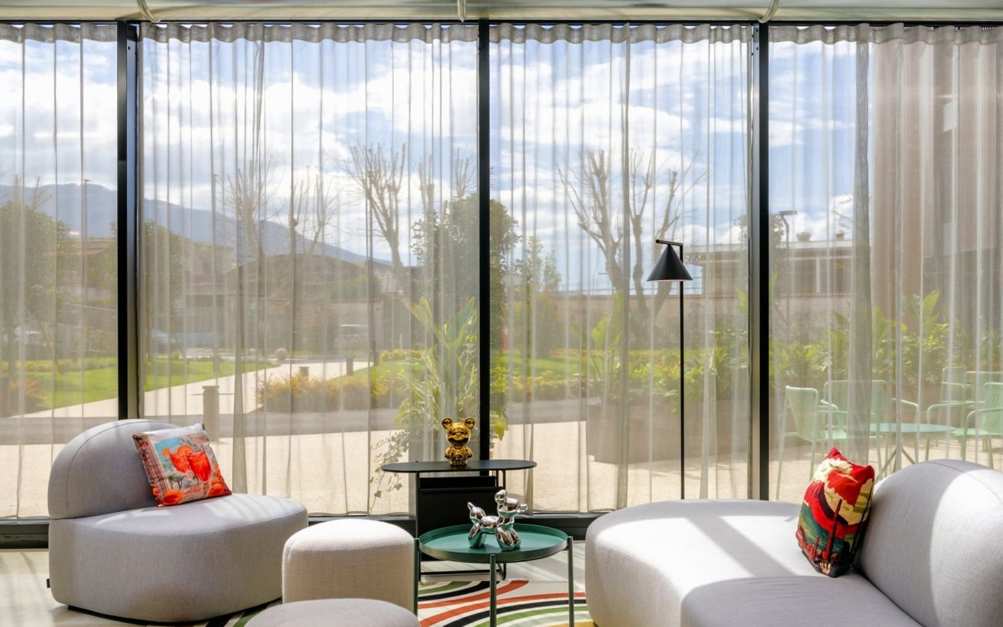 Moderne Hotel-Lounge mit gemütlichen Sitzmöbeln und großen Fenstern.