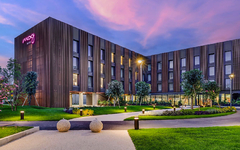 Hotel Moxy Pompeii bei Sonnenuntergang mit Garten und beleuchteten Wegen