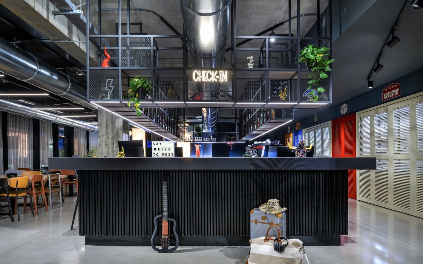 Rezeption im Hotel Moxy mit moderner Dekoration und Check-in-Schriftzug.
