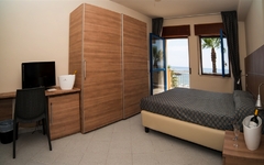 Hotelzimmer mit Meerblick, Bett, Schreibtisch und Schrank in Sizilien.