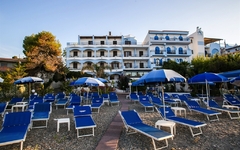Sonnenschirme und Liegestühle vor einem Hotel am Strand in Giardini Naxos, Sizilien.