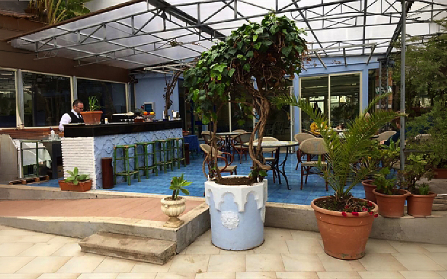 Terrasse eines Hotels mit Sitzgelegenheiten und Pflanzen in Italien.