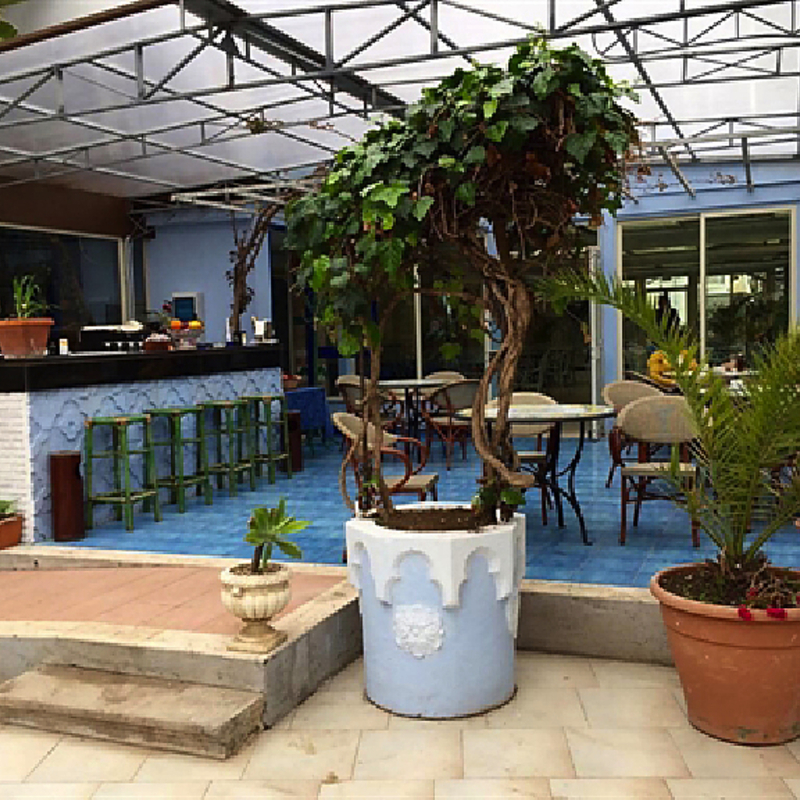 Terrasse eines Hotels mit Sitzgelegenheiten und Pflanzen in Italien.