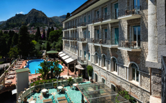 Außenansicht des Taormina Park Hotels mit Pool und Berglandschaft im Hintergrund.