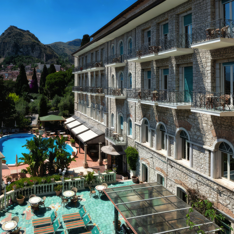 Außenansicht des Taormina Park Hotels mit Pool und Berglandschaft im Hintergrund.