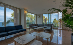 Hotel-Lounge mit Sofas, Marmortischen und Blick auf das Meer in Sizilien.