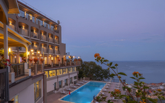 Hotel mit Pool und Meerblick bei Abenddämmerung in Sizilien