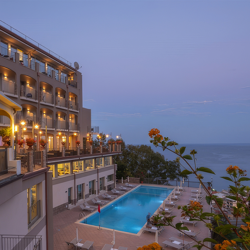 Hotel mit Pool und Meerblick bei Abenddämmerung in Sizilien