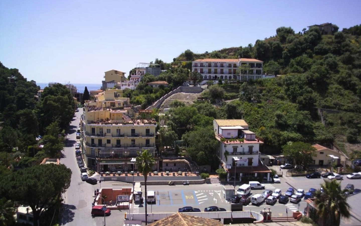 Straßenansicht mit Gebäuden und Hügeln in Taormina, Sizilien.