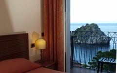 Blick aus einem Zimmer auf das Meer und eine Felsformation in Taormina, Sizilien.