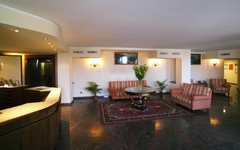 Lobby eines Hotels mit Sofas, einem runden Tisch und Pflanzen im Villa Bianca Resort.