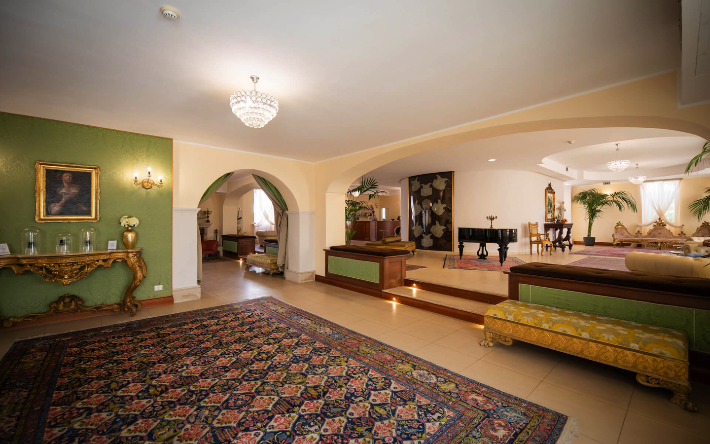 Elegante Hotellounge mit Teppich, Kamin, Gemälde und Sitzmöbeln.