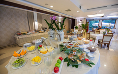 Frühstücksbuffet in einem Hotelrestaurant mit Obst und Blumentischdekoration.