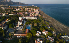 Luftaufnahme eines Küstenhotels mit Strand und umliegender Stadt in Sizilien.
