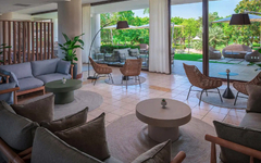 Moderne Hotel-Lounge mit Blick auf einen grünen Garten.