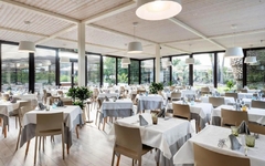 Heller Speisesaal mit gedeckten Tischen und großen Fenstern im Voi Arenella Resort.