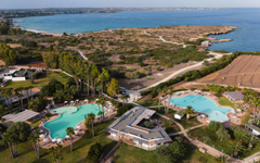 Luftaufnahme eines Resorts in Sizilien mit Pools und Blick auf das Meer.