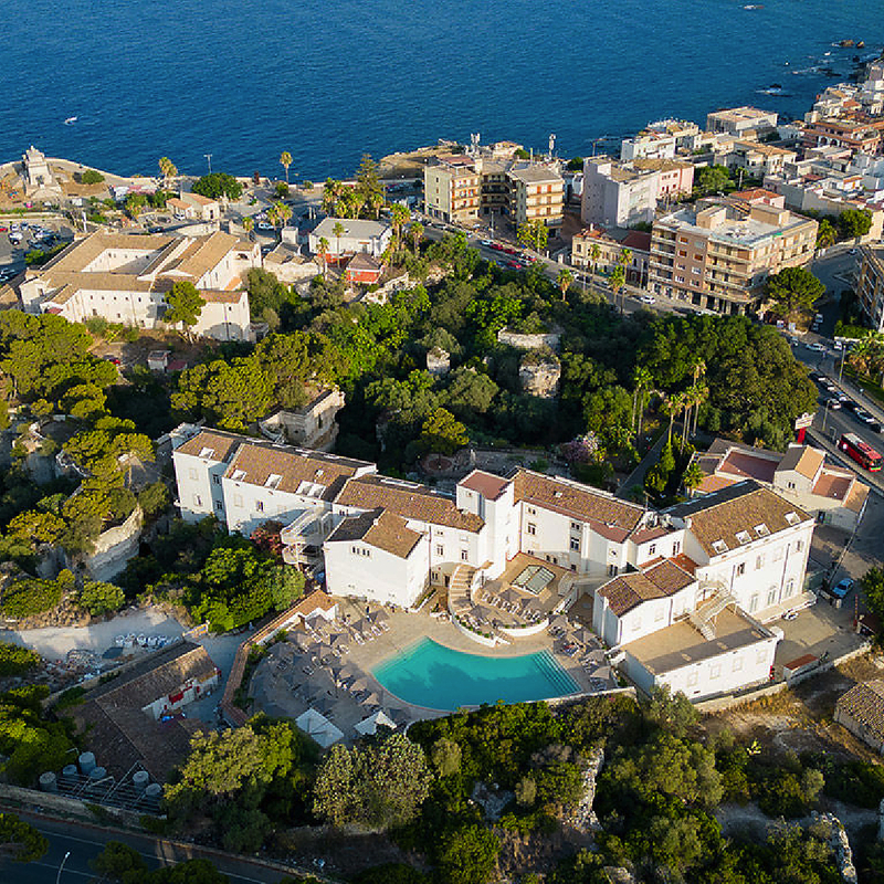 Luftaufnahme des Grand Hotel Villa Politi in Syrakus, umgeben von Bäumen und Gebäuden.