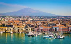 Blick auf Catania in Sizilien mit dem Ätna im Hintergrund und Jachthafen im Vordergrund.