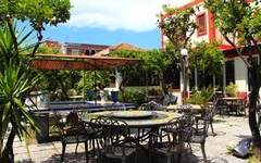 Terrasse eines Hotels auf den Liparischen Inseln mit Tischen und Stühlen im Freien.