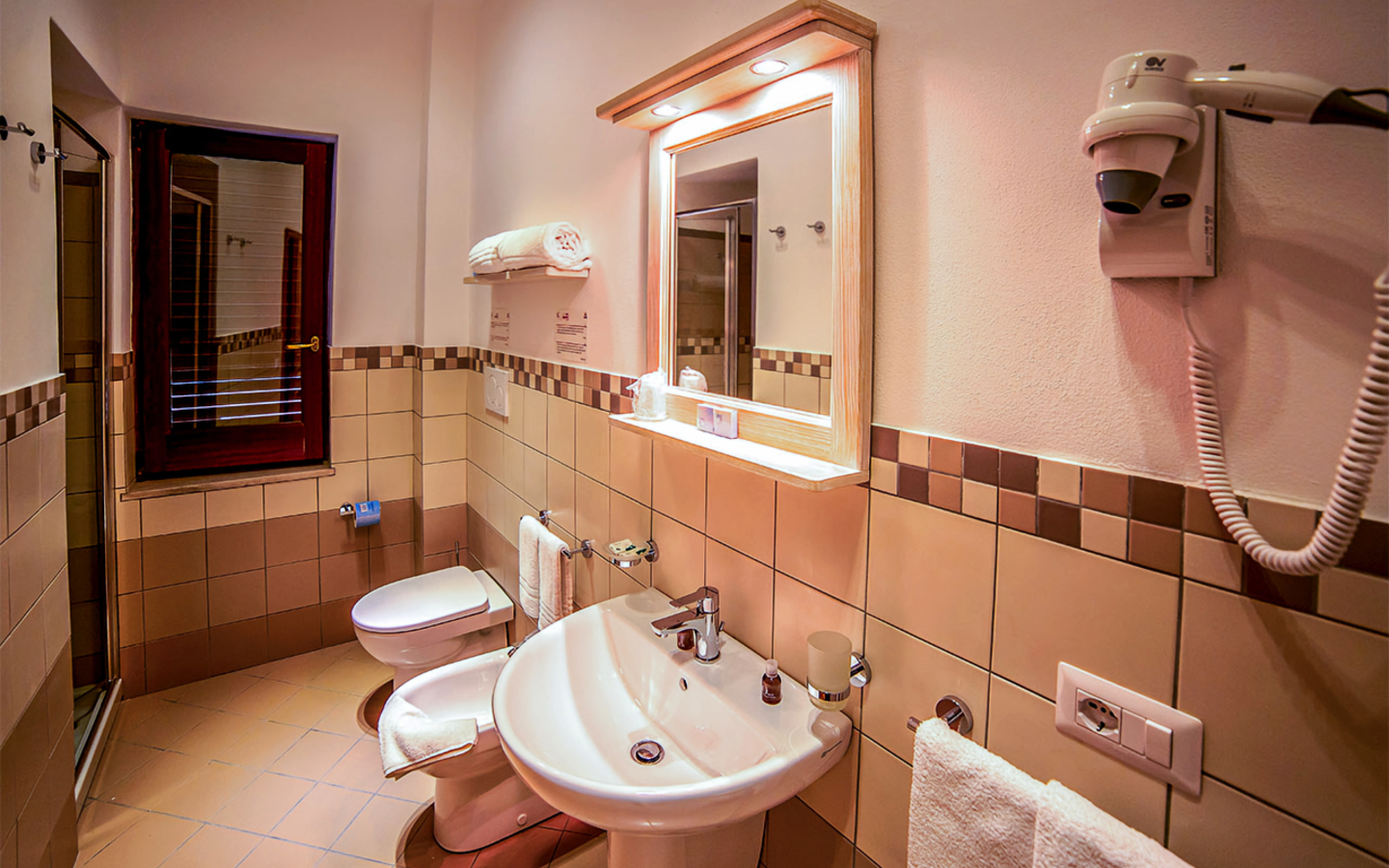 Badezimmer mit Waschbecken, Spiegel und Föhn im Hotel auf den Liparischen Inseln