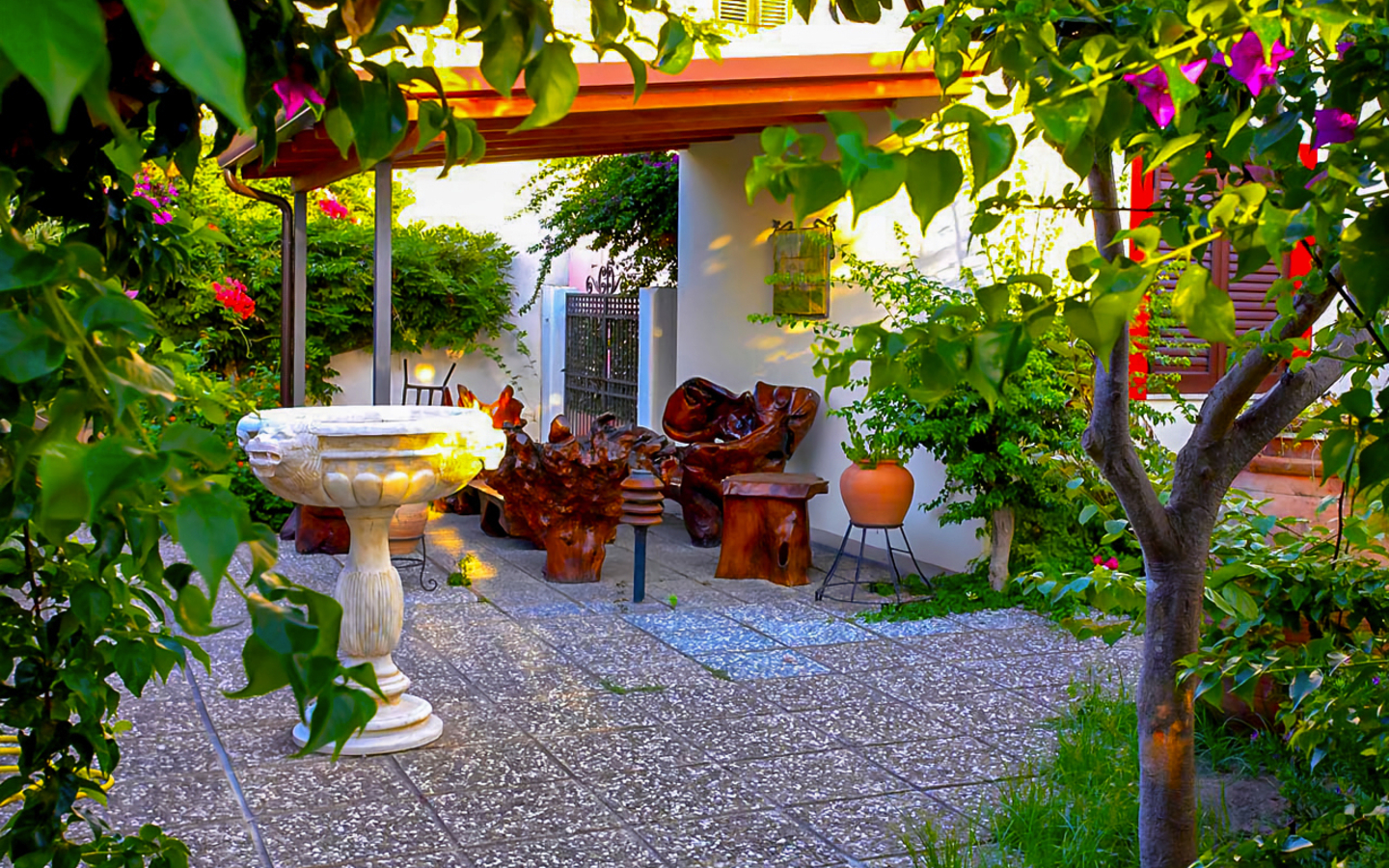 Gartenbereich mit Steinbank und Pflanztöpfen in einem Hotel auf den Liparischen Inseln.