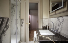 Hotelbadezimmer mit Marmordesign und moderner Dusche.