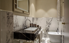 Modernes Badezimmer mit Waschbecken, Marmordetails und Bidet