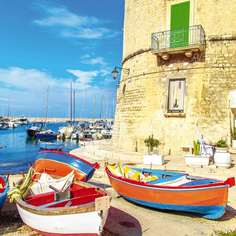 Bunte Fischerboote am Hafen von Giovinazzo, Apulien bei Sonnenschein.