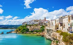 Panorama von Vieste, Apulien, Italien, mit Blick auf Häuser auf einer Klippe am blauen Meer.