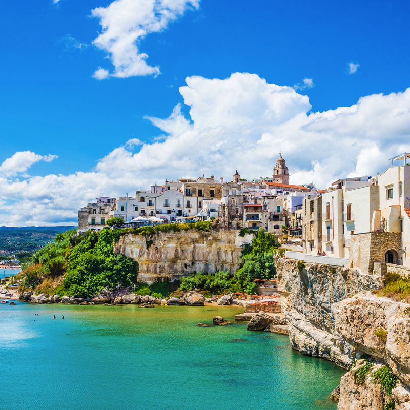 Panorama von Vieste, Apulien, Italien, mit Blick auf Häuser auf einer Klippe am blauen Meer.