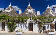 Trulli-Gebäude in Alberobello, Apulien, Italien mit dekorativen Dächern bei Sonnenschein.
